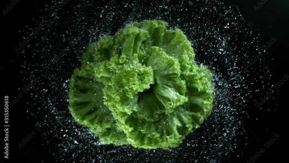 Super slow motion of rotating fresh salad with water drops. Filmed on high speed cinema camera, 1000 fps.