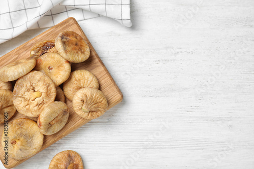 Tasty dried figs on white wooden table, flat lay. Space for text