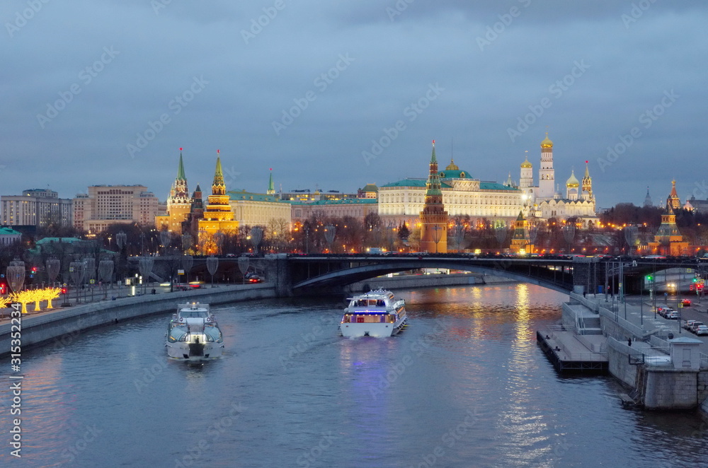 Evening view of the Moscow Kremlin, the Big Stone bridge and pleasure boats sailing along the Moscow-river. Moscow, Russia