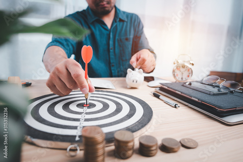 hand man with a dart in his hand pinning on the target board. target for saving and financial planning concept.