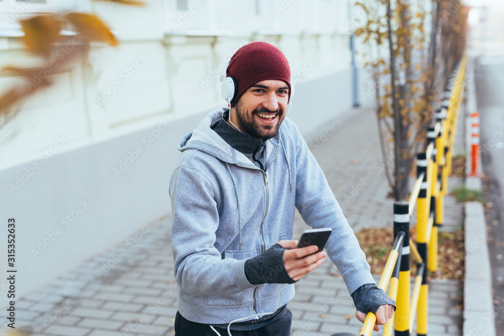 young man running outdoor, using cell phone young man running outdoor, using cell phone