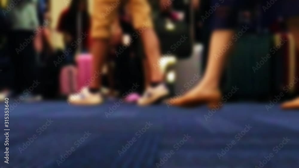 The detailed view of legs walks on carpet in hall, slow motion. A blurred passengers on to the airport. The detailed view of legs walks on carpet in hall, slow motion. A blurred passengers on to the airport.
