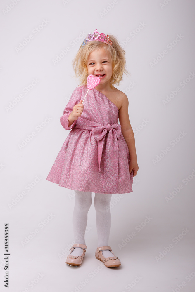 beautiful little blonde girl with a heart shaped Lollipop