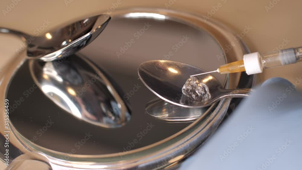 Close-up demonstration of hyaluronic acid filler in a spoon. Solid jelly-like soft material structure. Hyaluronic acid filler for injections squeezed out from the syringe on a spoon (mirror surface Close-up demonstration of hyaluronic acid filler in a spoon. Solid jelly-like soft material structure. Hyaluronic acid filler for injections squeezed out from the syringe on a spoon (mirror surface
