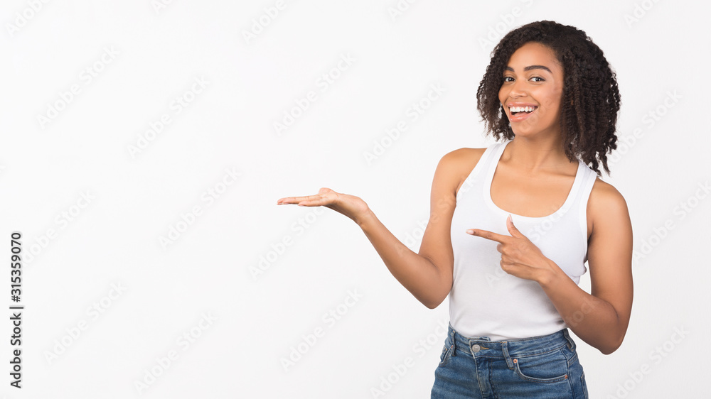 Excited black girl pointing at hand for promo Excited black girl pointing at hand for promo