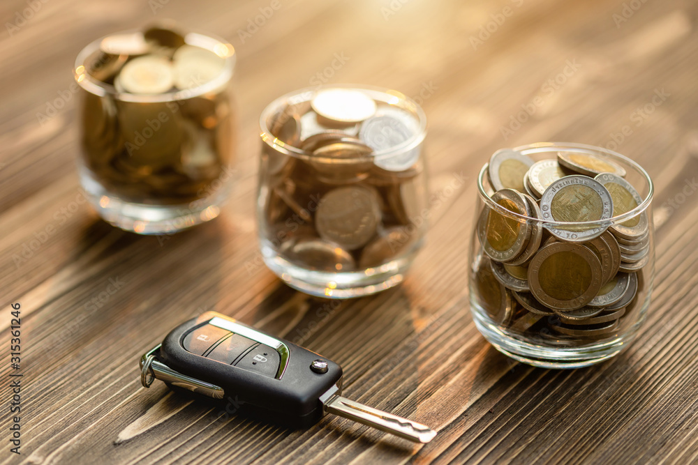 New car keys pile of coin on wooden table. Car financial, Car purchase, or car rental concept New car keys pile of coin on wooden table. Car financial, Car purchase, or car rental concept