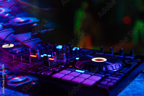 music mixer DJ controller in booth at nightclub