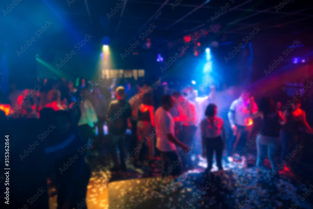 silhouettes of a crowd of people dancing in a nightclub on the dance floor at a party