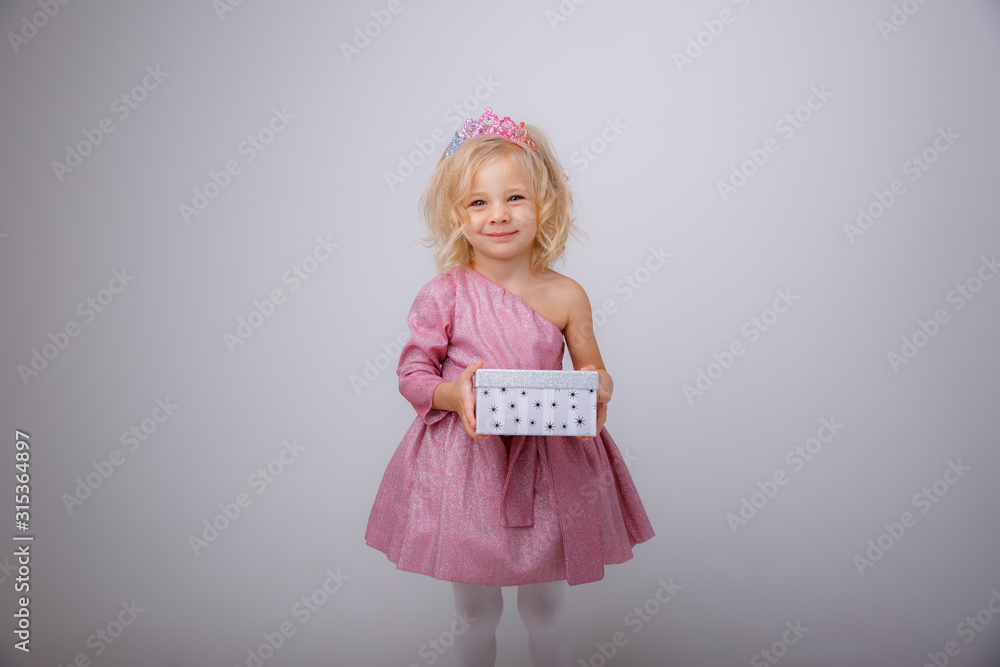 cute little girl in a princess dress with a crown holding a gift on a white background cute little girl in a princess dress with a crown holding a gift on a white background