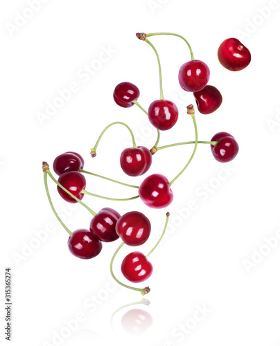 Cherries frozen in the air in a chaotic manner on a white background