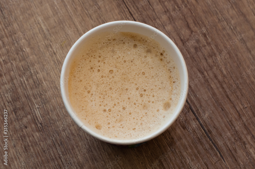 Cappuccino with a delicious foam in a paper cup, top view, coffee to go Cappuccino with a delicious foam in a paper cup, top view, coffee to go