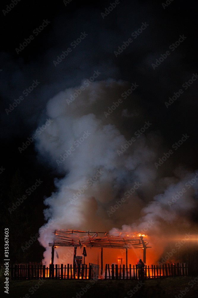 Obraz premium Long shot of a Fire. Unrecognizable Fireman rescue the country house.