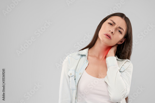 Woman touching neck because of pain.
