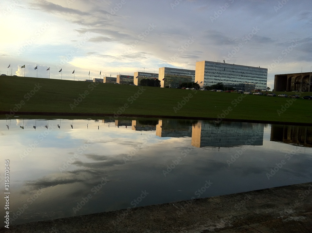 Esplanada dos Ministérios vista do gramado do Congresso com reflexo no lago do Congresso Nacional