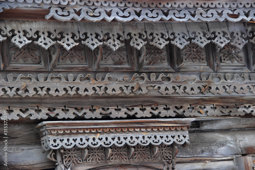 The facade of the old wooden house is decorated with patterns made of wood.