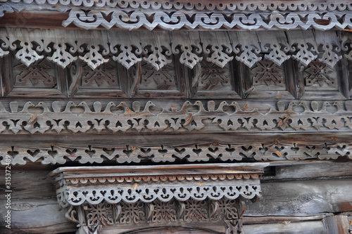 The facade of the old wooden house is decorated with patterns made of wood.