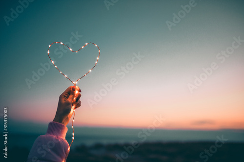 Simbolo del cuore per San Valentino con striscia di luci led. Sfondo del cielo. photo