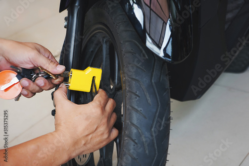 Obraz na płótnie Motorcycle owner use a disc brake lock on a motorbike