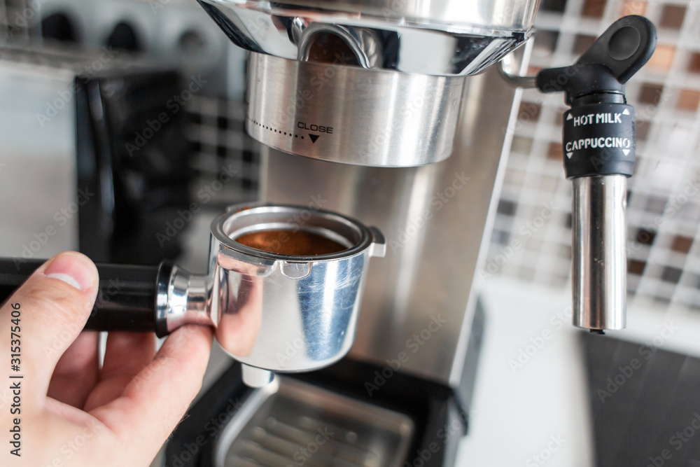 Guy prepare delicious aromatic coffee in a coffee machine. A simple way to make coffee