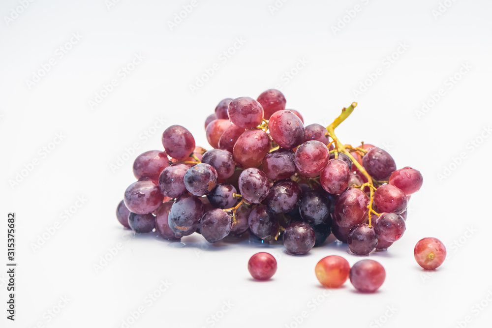 A bunch of red grapes isolated on a white background.