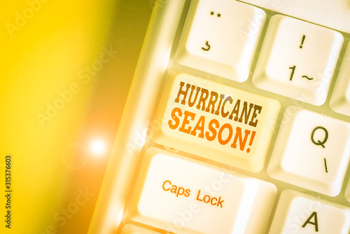 Conceptual hand writing showing Hurricane Season. Concept meaning time when most tropical cyclones are expected to develop White pc keyboard with note paper above the white background photo