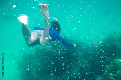 Man diving in emerald andaman sea on coral