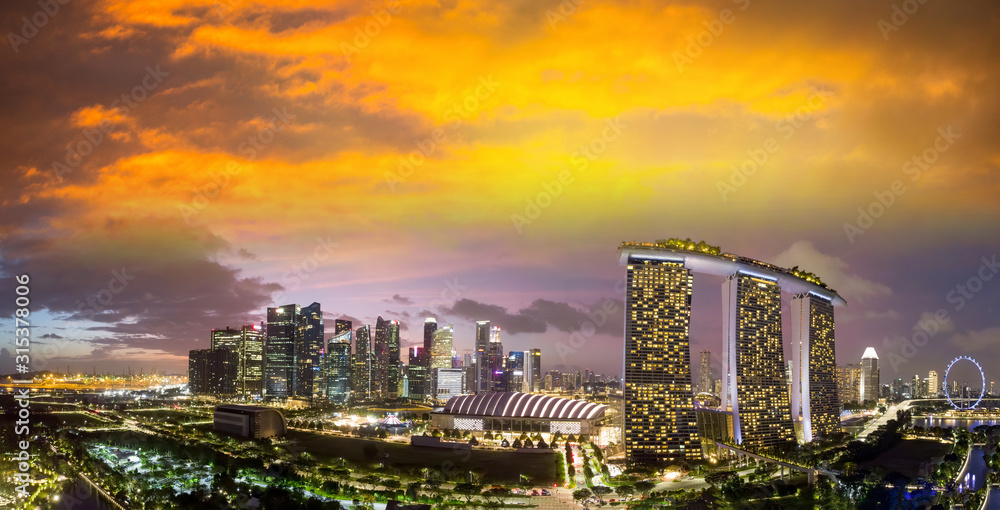 Fototapeta premium Singapore at sunset. Aerial view of Marina Bay and Downtown from drone