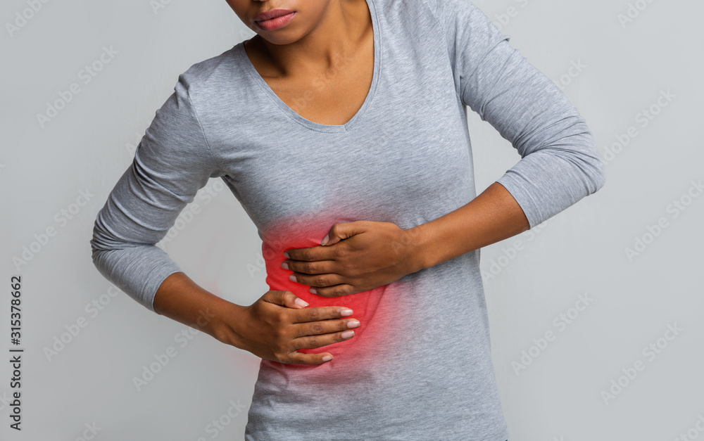 African woman holding her side, suffering from liver pain - obrazy, fototapety, plakaty 
