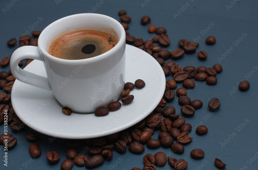 White cup of coffee and beans on blue table. Coffee shop, espresso, high angle, closeup, template White cup of coffee and beans on blue table. Coffee shop, espresso, high angle, closeup, template