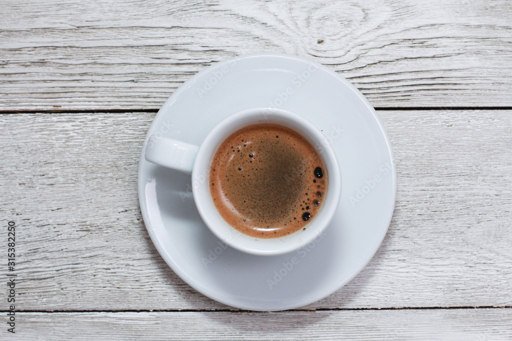 White cup of coffee on white wooden table. Coffee shop, espresso, top view, copy space, template White cup of coffee on white wooden table. Coffee shop, espresso, top view, copy space, template