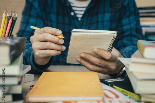 high school,university student study.hands holding pencil writing paper answer sheet.sitting lecture chair taking final exam attending in examination classroom.concept scholarship for education abroad