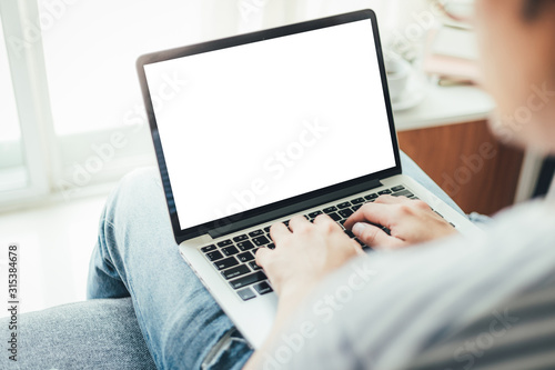 mockup image blank screen computer with white background for advertising text,hand man using laptop contact business search information on desk at coffee shop.marketing and creative design