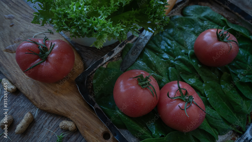 Tomato, green salad and spinach leaves on the table. Still life Tomato, green salad and spinach leaves on the table. Still life