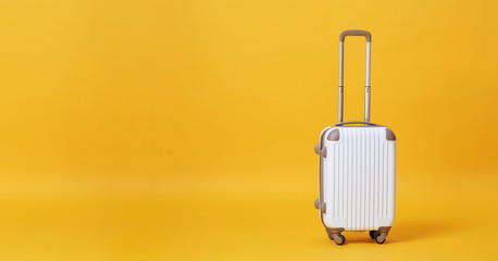 White luggage bag isolated on yellow banner background with copy space for advertisement..