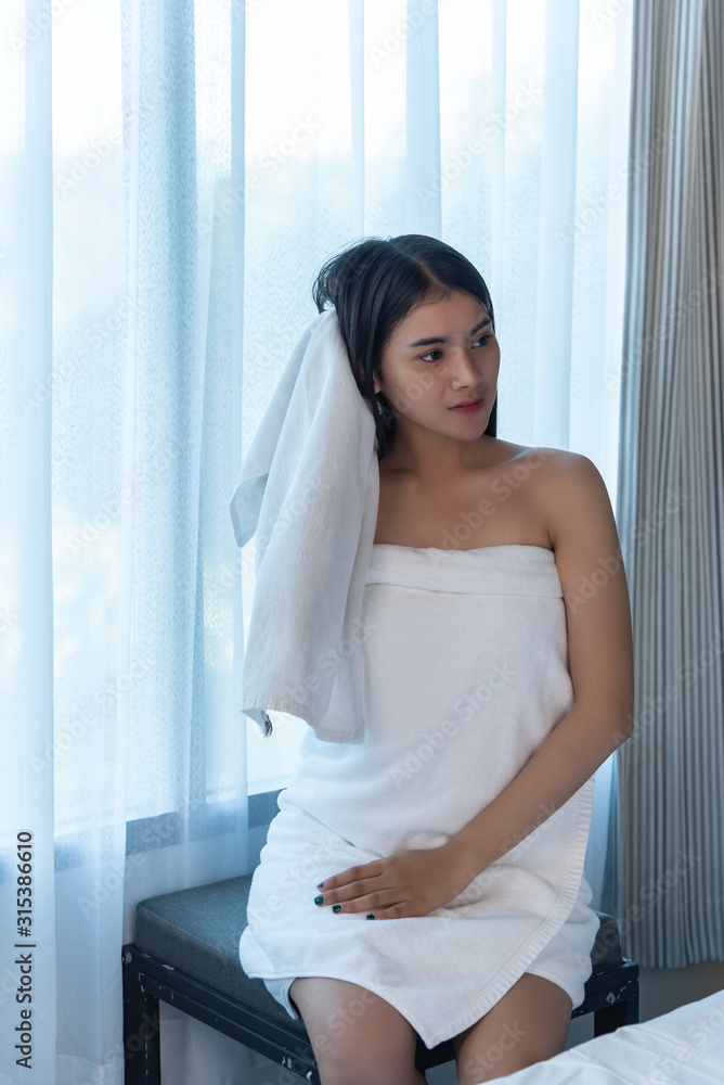 young teenage woman siting side window ,using towel wipe hair in the morning.relex time. young teenage woman siting side window ,using towel wipe hair in the morning.relex time.
