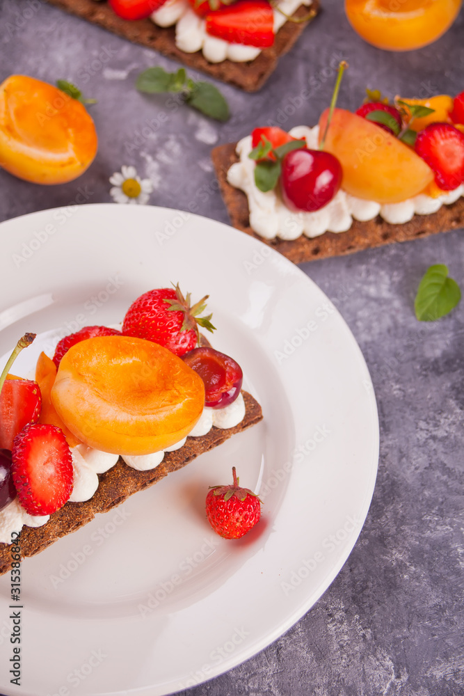 Crisp bread with creme cheese, fruit and berries