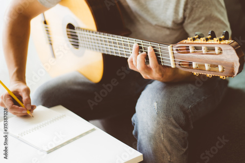 artist songwriter thinking writing notes,lyrics in book at studio.man playing live acoustic guitar relax chill.concept for musician creative.composer work process.people relaxing time with instrument