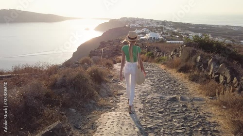 lovely and fashionable girl or woman in white pants or jeans walking in greece cycladic island santorini