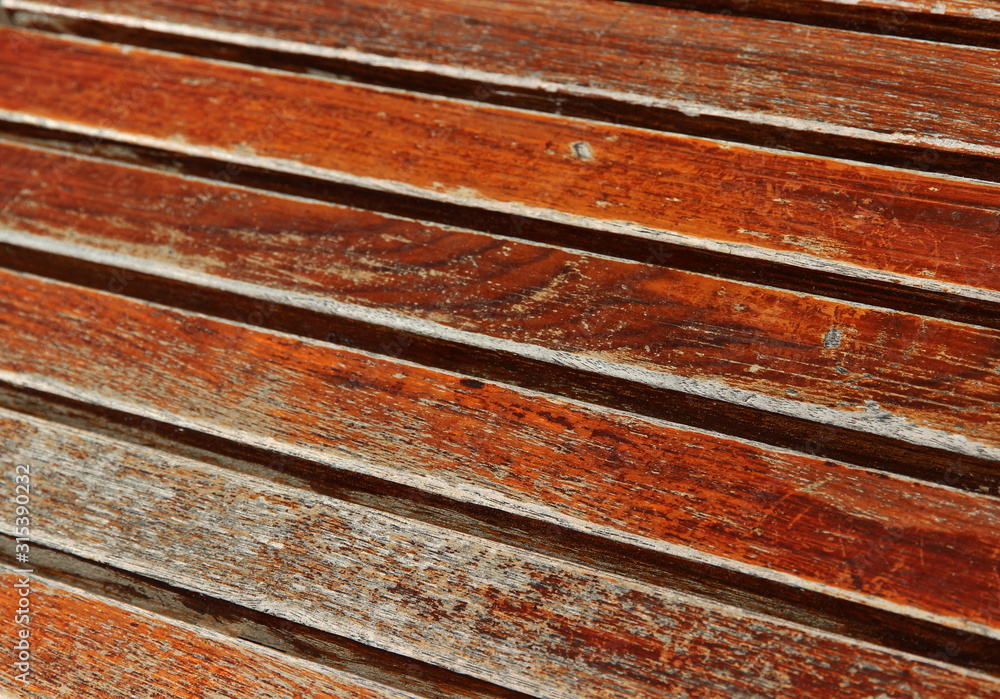 A close up color image of weathered boards taken on a slant.