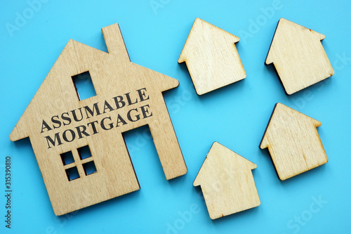 Assumable Mortgage sign on small model of house.
