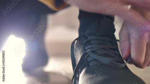 Jogger tying sneaker shoelaces before running photo