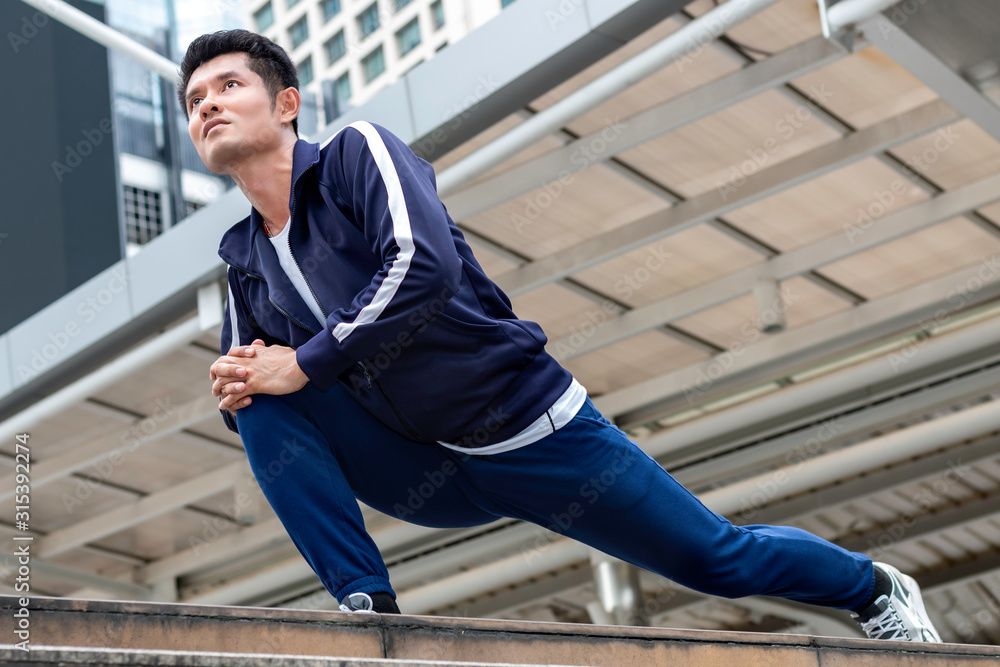 Athlete Asian man in running start pose on the city street. Athlete Asian man in running start pose on the city street.