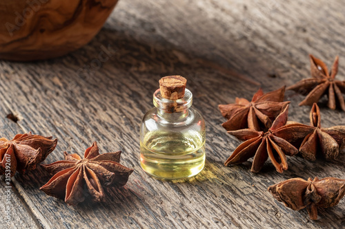 A bottle of star anise essential oil with dried star anise