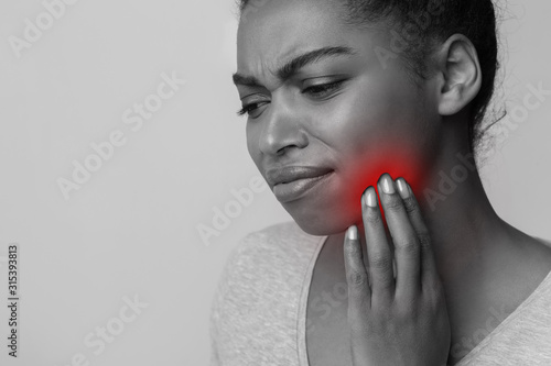 Monochrome photo of afro lady suffering from toothache