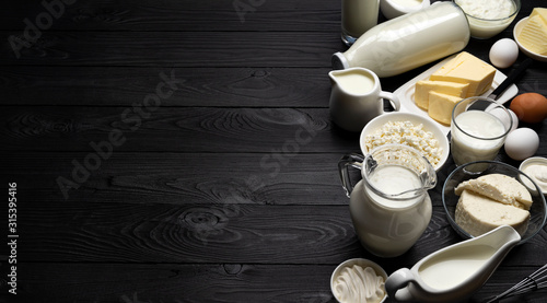 Vászonkép Dairy products on black wooden background, top view