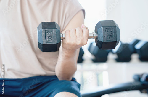 Photo Man doing concentration curls exercise working out with dumbbell
