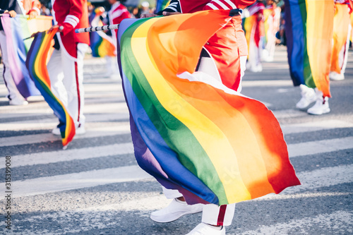 Hands waving the rainbow colored flags. Selected focus. Copy space. 