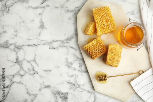 Flat lay composition with delicious honey on white marble table. Space for text
