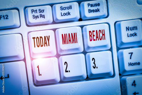 Writing note showing Miami Beach. Business concept for the coastal resort city in MiamiDade County of Florida Keyboard with note paper on white background key copy space photo