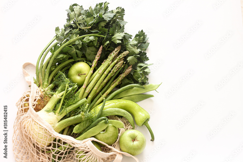 Green vegetables and fruits in string bag on white background. Green vegetables and fruits in string bag on white background.